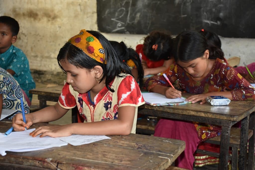 Mädchen bei den Schulaufgaben in Kurigram Bangladesch